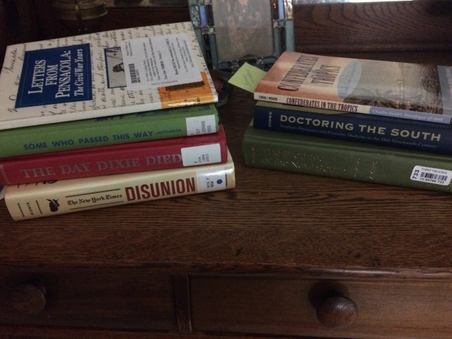 The pile on the right belong to me; the pile on the left courtesy of my UMUC LIbrarian Overlords. I also have a reel of microfilm on the cued up. Busy!