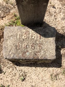 In brass, the years 1861 and 1865. This is right below the footstone with his initials.